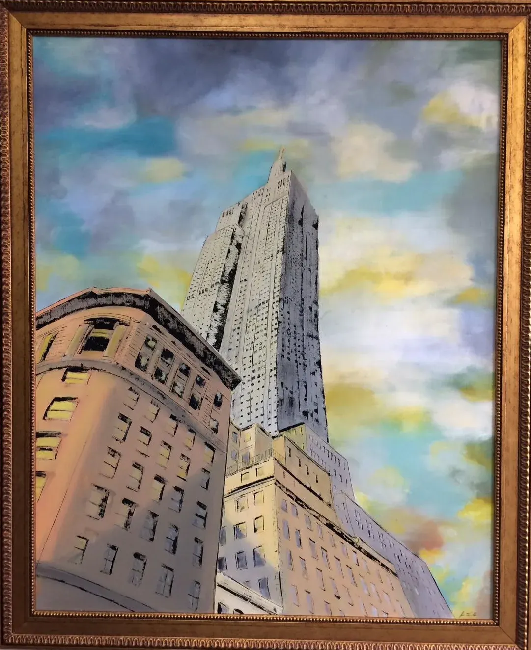 A setback skyscraper seen from the pavement, leaning up into a sky of blue and yellow cloud, with a curved masonry corner building in the foreground.