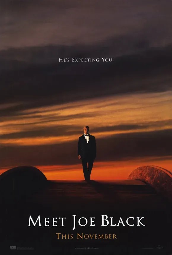 A man in a dinner jacket alone on a rooftop against a burnt-orange dusk.